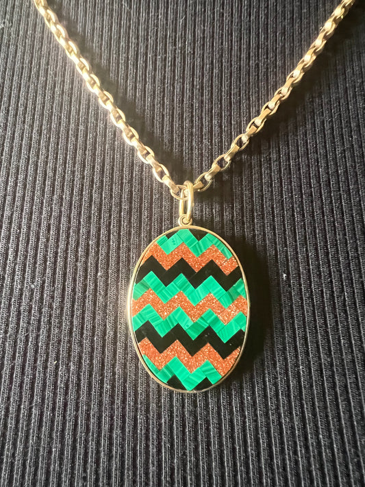 Inlaid malachite, onyx and goldstone pendant set in 14k gold